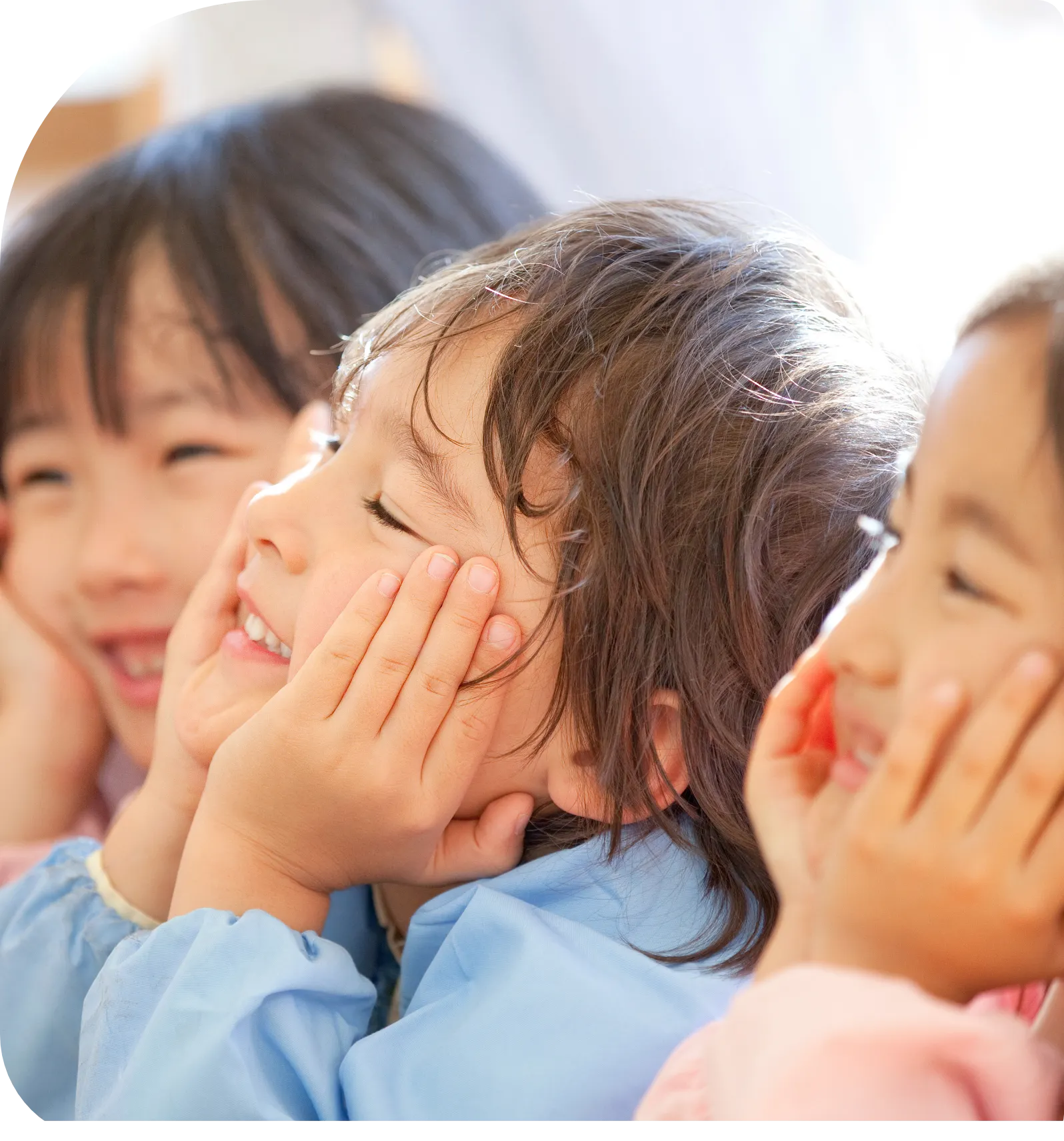 施設内で、笑顔で話を聞いている未就学児の子供達